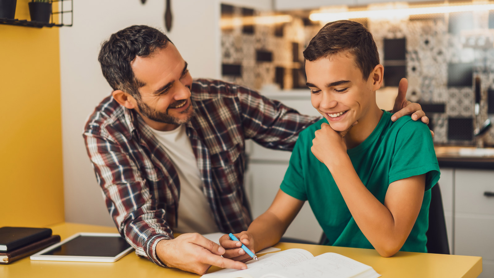 Father helps his son with his homework.